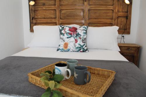 a bed with a basket and two mugs on it at CASA SIETE LAGOS in Sinlabajos
