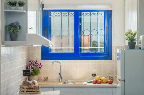 チィリヴィにあるTsilivi Blue Vista Apartmentの青い窓とシンクのあるキッチン