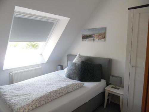 una camera da letto con un letto e una finestra di Landhaus Martina a Krummhörn
