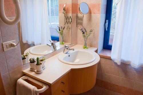 a bathroom with two sinks and a mirror at Apartments Casa Trasparente in Arcugnano
