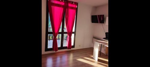 um quarto com uma janela com cortinas vermelhas em Jolies Appartement 6 couchages a praloup 1600 avec balcons em Uvernet