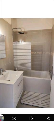 a bathroom with a white tub and a sink at Jolies Appartement 6 couchages a praloup 1600 avec balcons in Uvernet-Fours