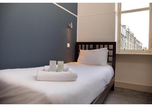 a bedroom with a bed with two towels on it at JOIVY Haymarket in Edinburgh