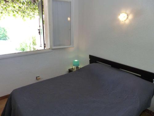 ル・ラヴァンドゥーにあるMaison Le Lavandou, 2 pièces, 6 personnes - FR-1-308-46のベッドルーム1室(青い毛布、窓付)