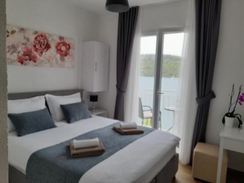 - une chambre avec un grand lit et un balcon dans l'établissement Apartments Palma, à Polače