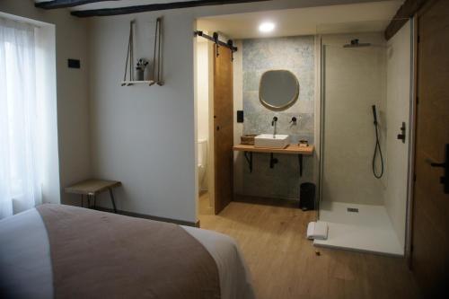 a bathroom with a bed and a sink and a mirror at Fábrica de Harinas La Gloria in San Millán de la Cogolla
