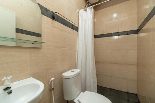 a bathroom with a white toilet and a sink at RedDoorz @ Jalan Srikandi Pekanbaru in Parit