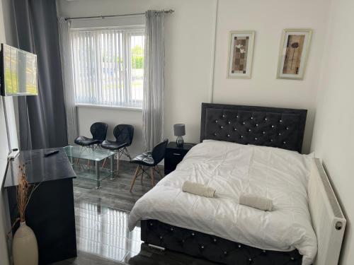 a bedroom with a bed and a table and a window at Zams rooms in Stoke on Trent