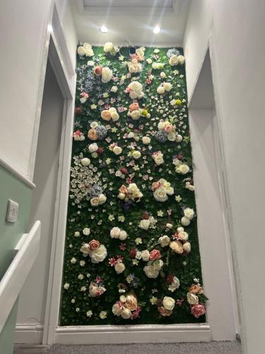 a wall full of flowers in a room at Zams rooms in Stoke on Trent