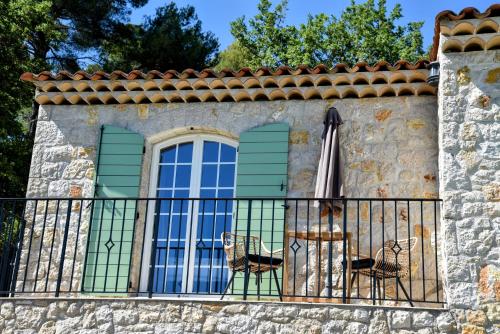 a balcony with a table and an umbrella at Chambre d'hôtes Cottes in Callian