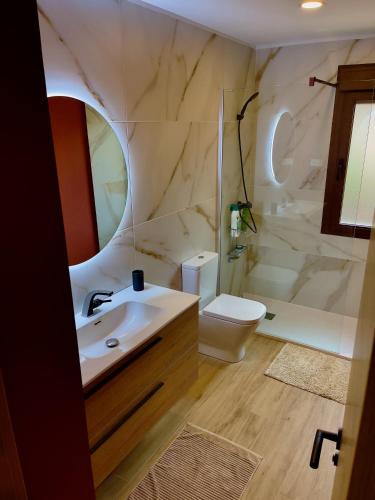 a bathroom with a sink and a toilet and a shower at La Casa OM in Almorox