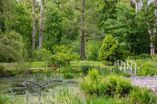 a garden with a bridge in the middle of a pond at Villa Granliden in Ludvigsborg