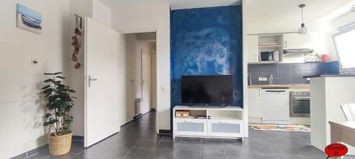 a living room with a tv on a white cabinet at MADININA DAY in Saint-Médard-en-Jalles