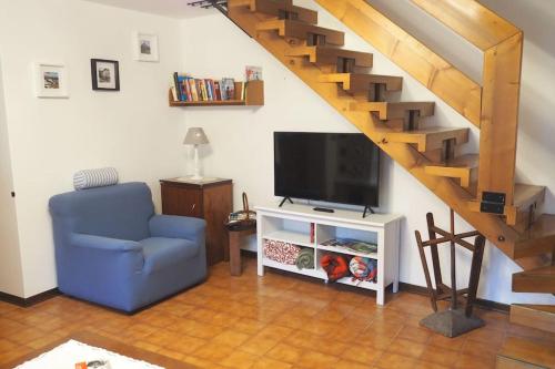 sala de estar con silla azul y TV en Dalla Dora- A peaceful place in the Dolomites, en Villa