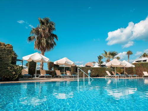 a large swimming pool with umbrellas and chairs at Mitsis Royal Mare in Hersonissos