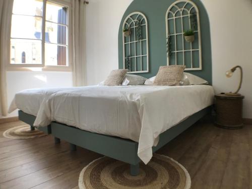 1 cama en un dormitorio con cabecero verde en Dépendance Saint Jean en Bouniagues