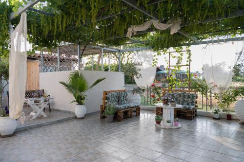 a patio with chairs and plants in a greenhouse at Sea View Residence in Néa Kíos