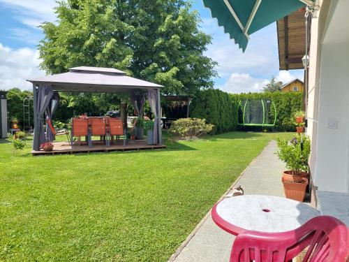 a garden with a table and a gazebo at Studio apartma Žirovnik in Cerklje na Gorenjskem