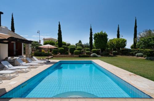 een zwembad in een tuin met stoelen en bomen bij Villa Lara - 11 in Kouklia