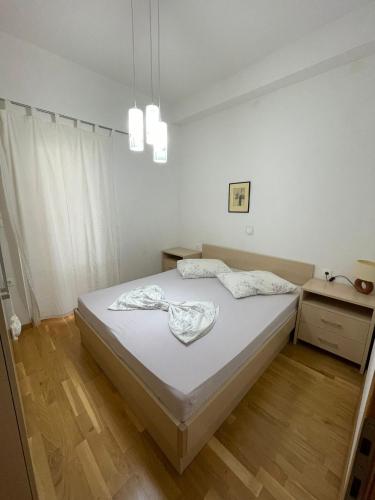 a bedroom with a white bed and a wooden floor at Family House LA - Krvavica in Makarska