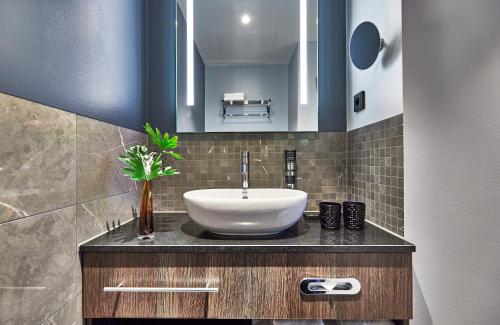 a bathroom with a sink and a mirror at NYX Hotel Warsaw by Leonardo Hotels in Warsaw