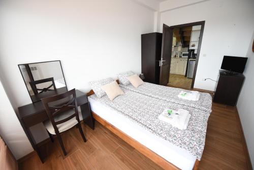 a small bedroom with a bed and a table at Jovanovic Guest House in Ohrid
