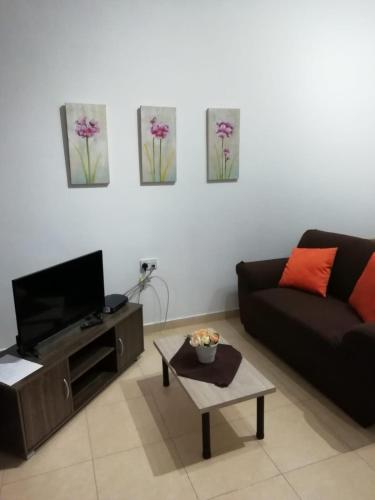 - un salon avec un canapé et une table dans l'établissement San Anton Studio Apartment, à Taʼ Sardina