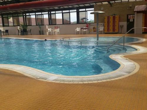 ein großes Schwimmbecken mit blauem Wasser in einem Gebäude in der Unterkunft Caravan Sleeps 4 with Free Parking in Burnham on Sea