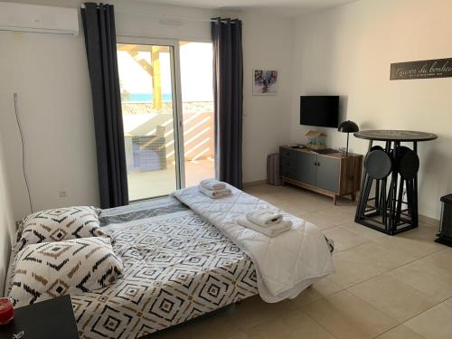a bedroom with a bed and a sliding glass door at Studio les pieds dans l'eau vue sur mer in Linguizzetta