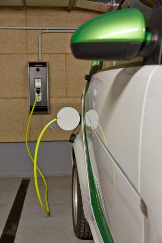 a electric car plugged into an outlet with a yellow wire at H4 Hotel München Messe in Munich
