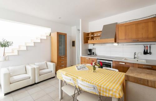 a kitchen with a table with a yellow checkered table cloth at Afitos Hidden Gems #FeelsLikeHome in Afitos