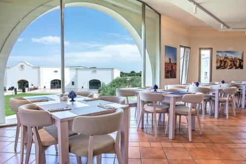 a dining room with tables and chairs and a large window at Acaya Golf Resort & Spa in Acaya