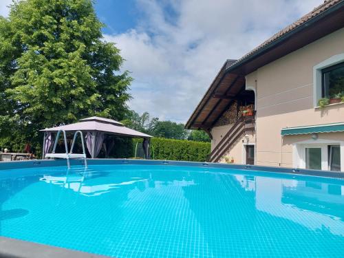a swimming pool with a gazebo next to a house at Apartma Žirovnik in Cerklje na Gorenjskem