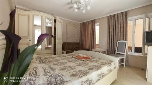 a bedroom with a bed and a table with a flower at Samira in Gagra