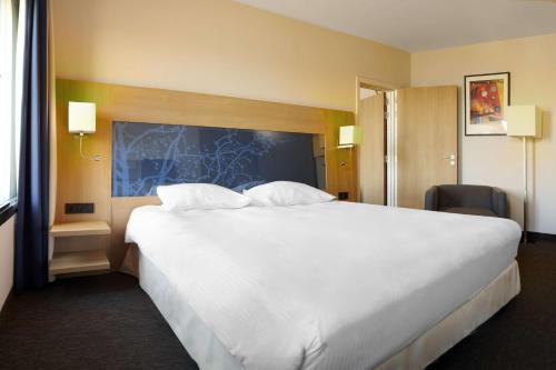 a large white bed in a hotel room at Park Inn by Radisson Liege Airport in Liège