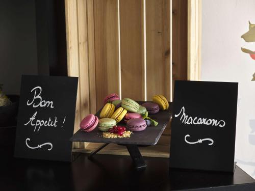 a tray of donuts on a table with two signs at Park Inn by Radisson Liege Airport in Liège