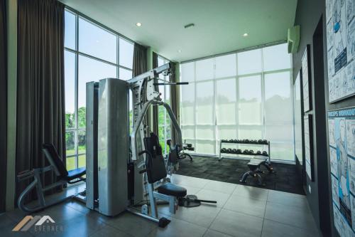 a gym with a treadmill and bikes in a room with large windows at Serene Heights by Evernent in Miri