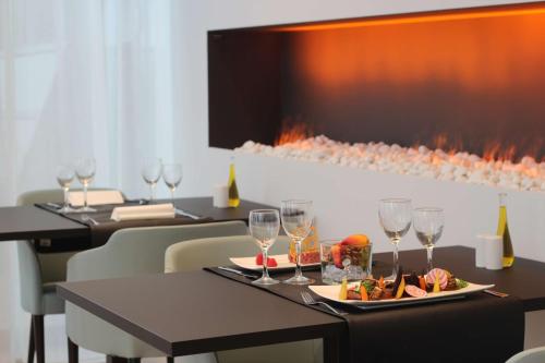 a table with a plate of food and wine glasses at Park Inn by Radisson Liege Airport in Liège