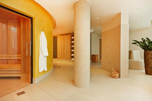 a bathroom with a pillar with a towel hanging on it at H4 Hotel München Messe in Munich