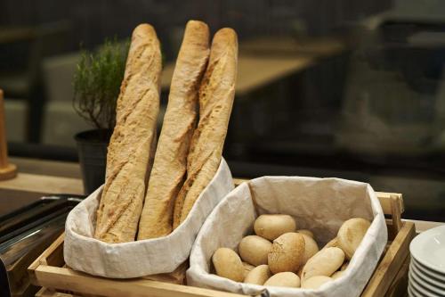 two baskets filled with bagels and bread on a table at Park Inn by Radisson Liege Airport in Liège