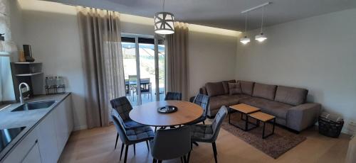 a kitchen and living room with a table and a couch at Vila Galadusis prie ežero in Lazdijai