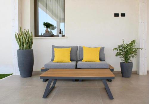 a couch with two yellow pillows and a table at Valenti rooms & relax in Villaggio Mosè