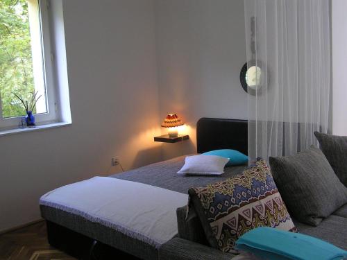 a bedroom with a bed and a window at Belvárosi Studio Apartman in Győr