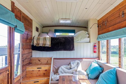 un interior de una casa pequeña con una cama y una mesa en The Hoot Romantic Glamping en Southwick