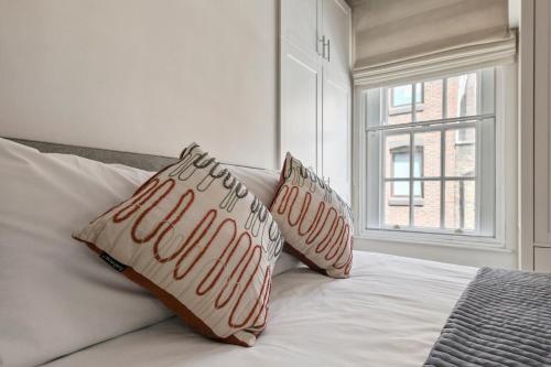 a bed with two pillows on it with a window at 1 Bed Executive Apartment near Liverpool Street Station FREE WIFI by City Stay Aparts London in London
