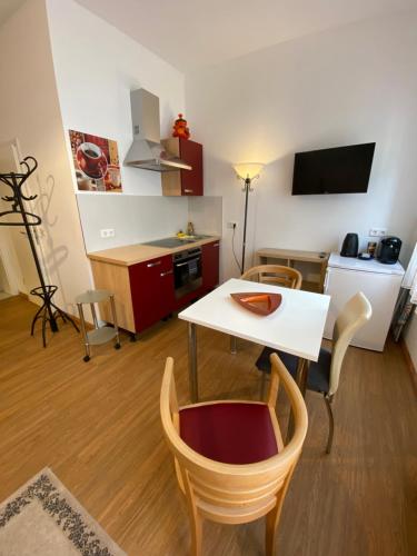 a living room with a table and chairs and a kitchen at City Apartment in Nürnberg in Nuremberg