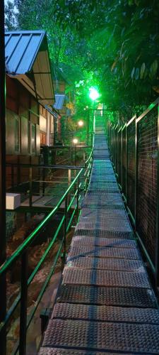 a walkway with a fence and trees at night at Santhi Hill View Resort in Munnar