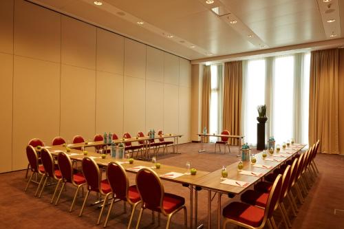 a large conference room with a long table and chairs at H4 Hotel München Messe in Munich