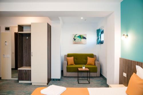 a living room with a green couch and a table at Vila GRANDE MAMAIA NORD in Mamaia Sat/Năvodari