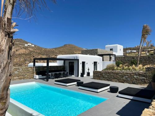 a swimming pool in front of a villa at BLACK AND WHITE VILLAS FTELIA - MYKONOS in Mýkonos City